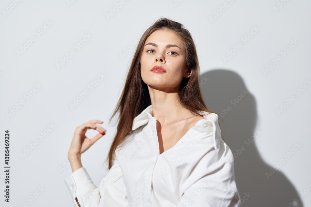 Portrait of a confident young woman with long hair in a white shirt against a light background, showcasing elegance and poise in a minimalist style Portrait of a confident young woman with long hair in a white shirt against a light background, showcasing elegance and poise in a minimalist style