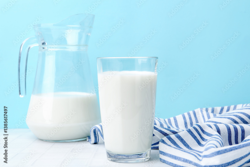 Fresh milk on white table against light blue background Fresh milk on white table against light blue background