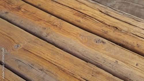 The image depicts a close-up view of an old, weathered wooden plank. The grain is visible and the color has a natural patina indicative of age.