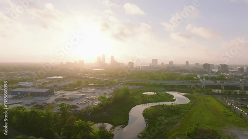 The Downtown Jacksonville Florida skyline at sunrise with the interstate bustling with rush hour traffic as seen from a drone.