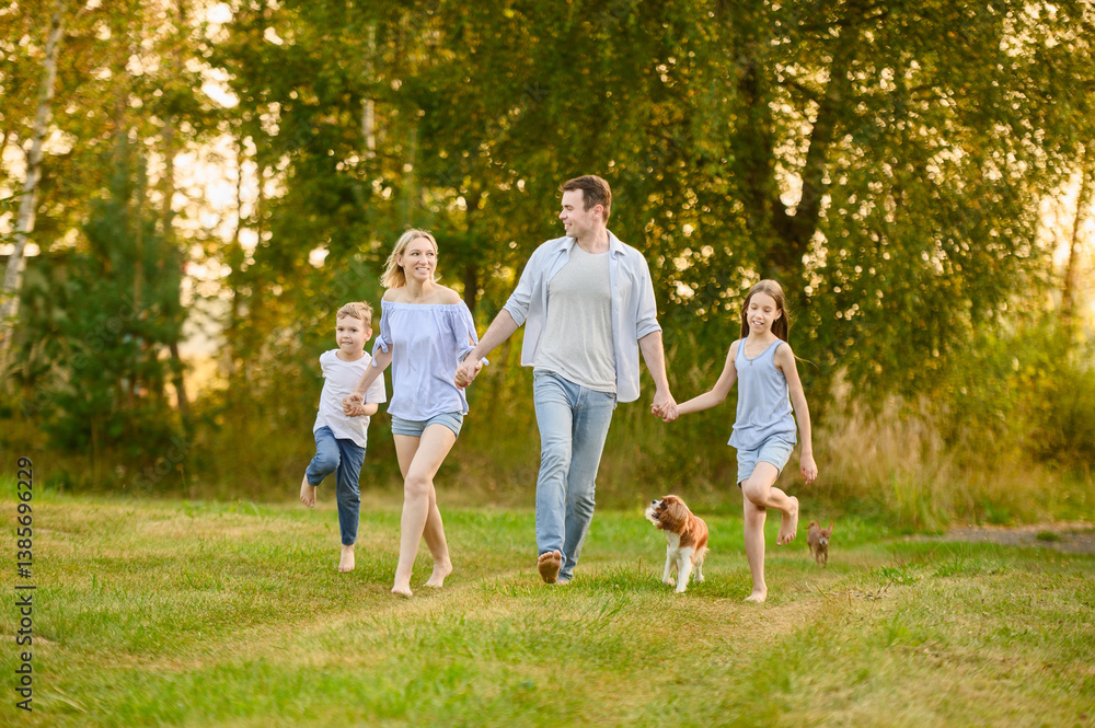 Family having fun outdoors running barefoot on grass, holding hands, laughing, with dogs running nearby. Summer weekend, country vacation concept. International Family Day Family having fun outdoors running barefoot on grass, holding hands, laughing, with dogs running nearby. Summer weekend, country vacation concept. International Family Day