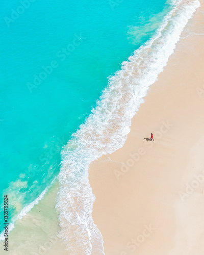 Breathtaking seascape of turquoise ocean waves caressing a soft white sandy shore in summer.