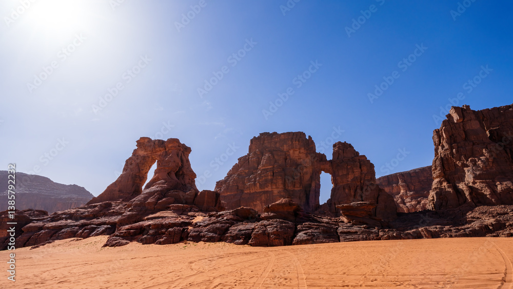 Fototapeta premium Arches in Tadrart Rouge, meaning Red Mountain, a mountain range in southeastern Algeria, part of the Algerian Desert providing massive dunes, rock formations and Martian landscapes