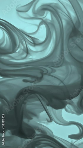 Abstract teal and black ink swirls mixing in water creating smooth, hypnotic flowing patterns. The liquid colors blend and transform gradually, creating elegant marble-like textures with copy space.