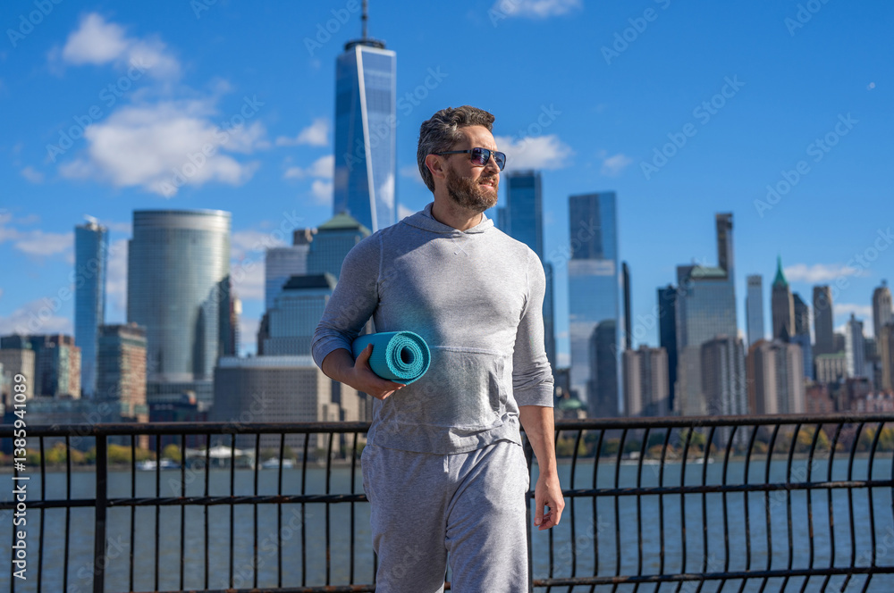 Obraz premium Sporting activity. Yoga coach. Sport man ready for workout. Healthy lifestyle. Fitness and sport. Yoga mat for training. Sportsman in New York. Man in sportswear with fitness mat in Manhattan