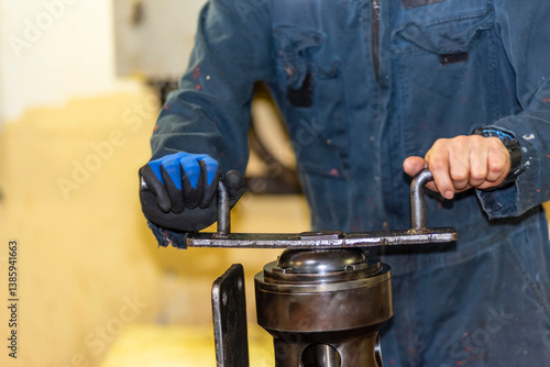 Φωτογραφία Engine room crew member standing over a repaired engine part on a cargo ship
