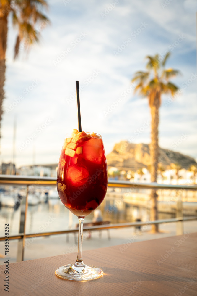 A glass of sweet and delicious Sangria at sunset on the coast of Spain. Concept. Vacation, tourist season. Rest and relaxation.