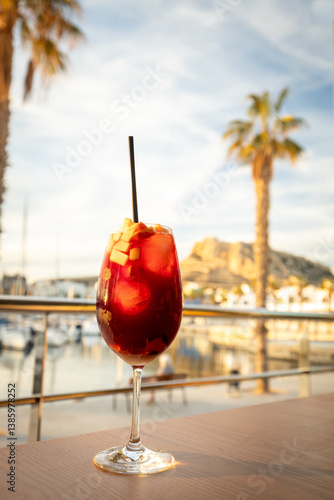 Obraz na płótnie A glass of sweet and delicious Sangria at sunset on the coast of Spain. Concept. Vacation, tourist season. Rest and relaxation. w salonie