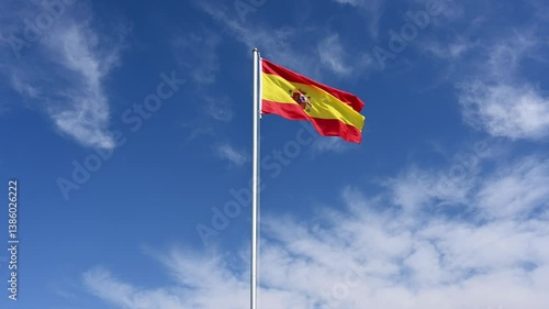 national flag of Spain is hoisted, flutters in the wind and is pulled down again