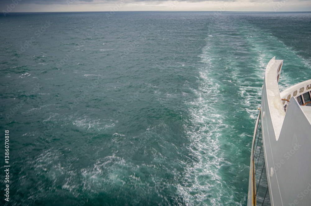 Views onto wet outdoor teak balcony terrace veranda promenade boat deck of ocean liner cruiseship cruise ship with chairs and loungers at sea during