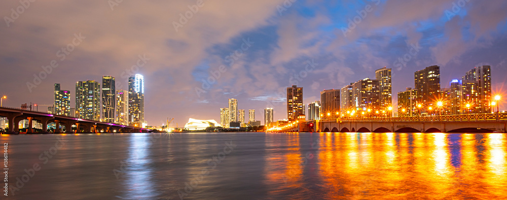 Fototapeta premium Miami city skyline panorama at night skyscrapers and bridge over sea with reflection