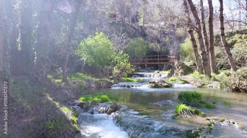 Beautiful path along the river with a wooden bridge, aerial shot