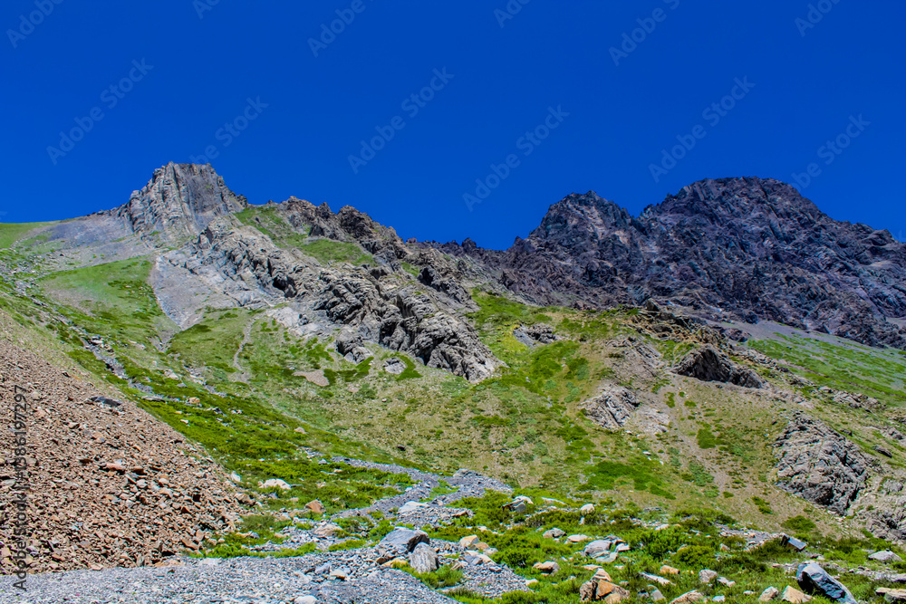 Fototapeta premium Andes mountains beautiful landscape in early spring with melting snow on the mountain slopes and lakes. Volcano San Jose in the high altitude Andes in Santiago de Chile area