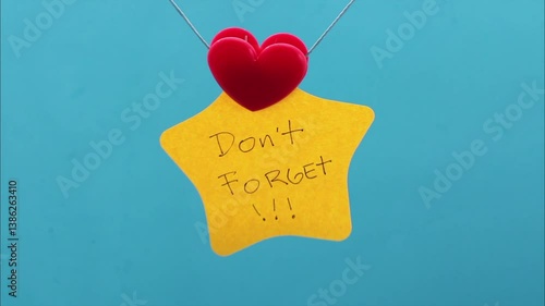 Clip holding a sticky note with a don't forget phrase