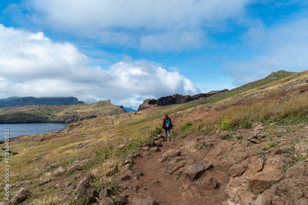 Fototapeta premium Hiker Walking Along Scenic Cliffside Trail by the Ocean