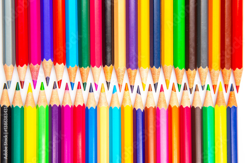 A rainbow of colored pencils stacked in a grid formation on a white background. Perfect for promoting creativity, school essentials, or art-related content.