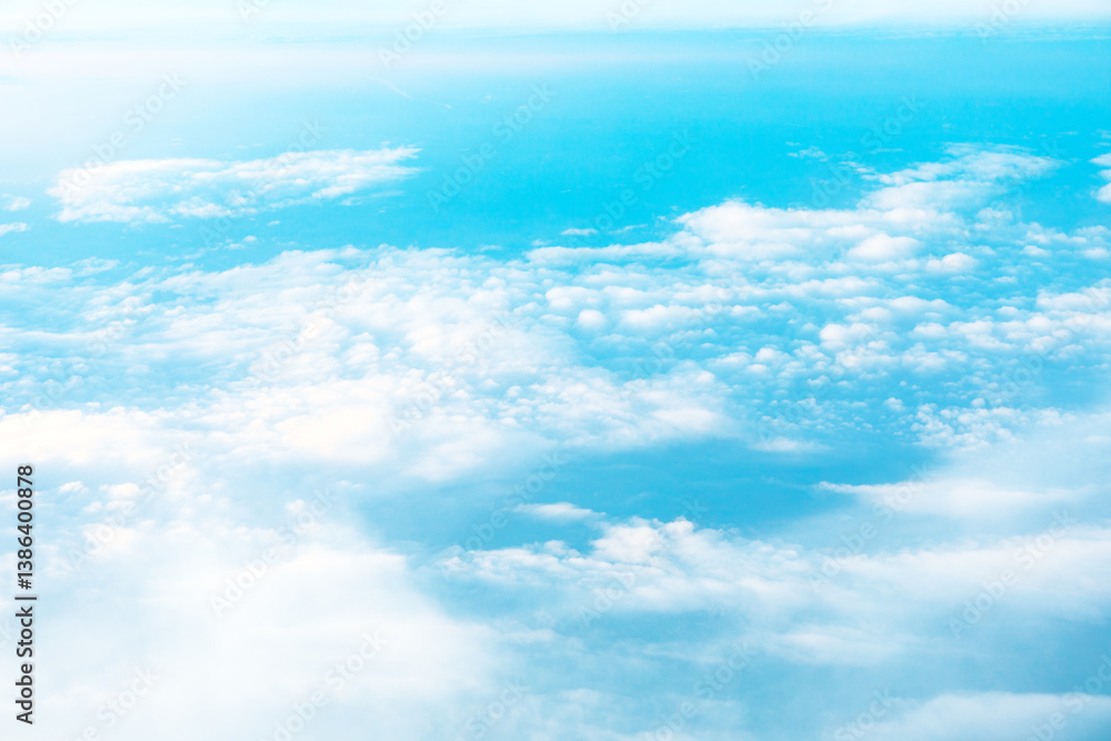 High altitude view of cumulus clouds against a vibrant azure backdrop. aerial soft white clouds drifting across blue sky. Serene panorama of clouds and sky, showcasing a tranquil atmosphere