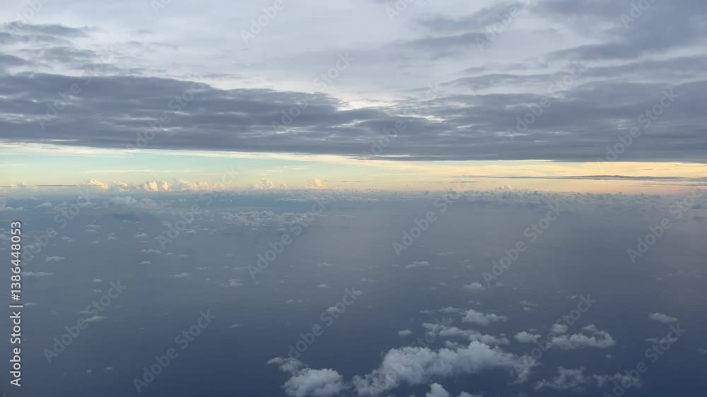 Aerial view of tranquil ocean at sunrise with scattered clouds and dramatic sky, capturing the peaceful essence of early morning above the sea. Aerial view of tranquil ocean at sunrise with scattered clouds and dramatic sky, capturing the peaceful essence of early morning above the sea.
