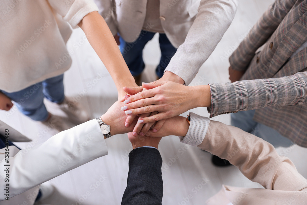 Fototapeta premium Unity concept. People holding hands together indoors, top view