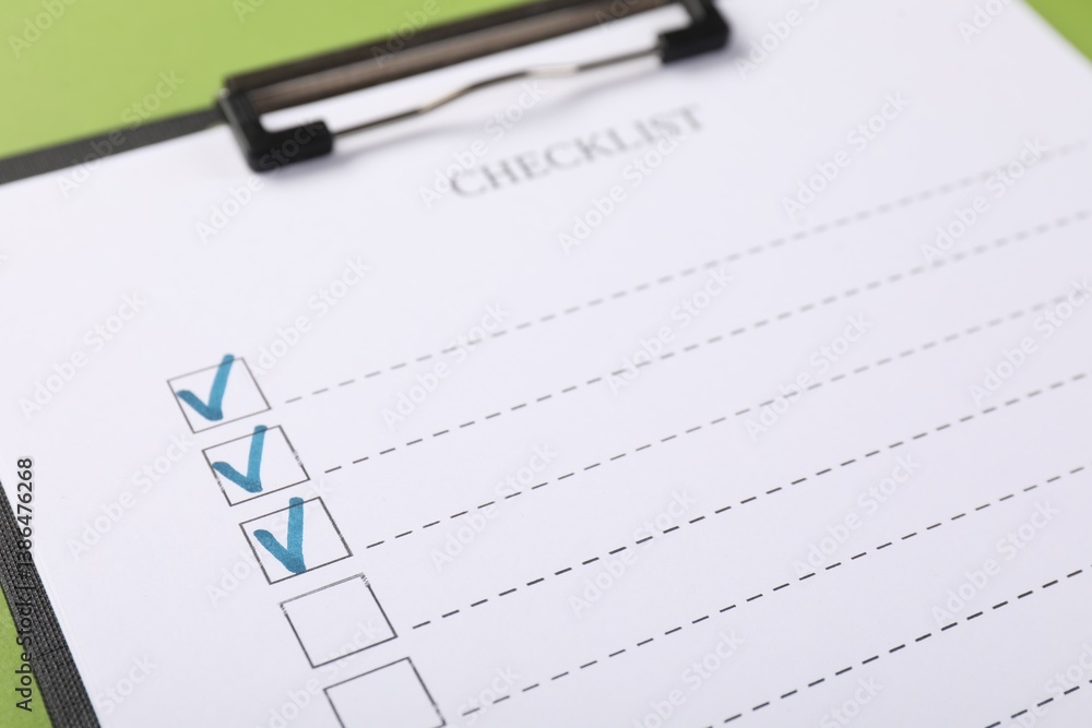 Checklist with marked checkboxes on green background, closeup Checklist with marked checkboxes on green background, closeup