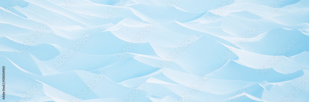 Snow texture. Wind sculpted patterns on snow surface. Wind in the tundra and in the mountains on the surface of the snow sculpts patterns and ridges (sastrugi). Arctic, Polar region. Winter background