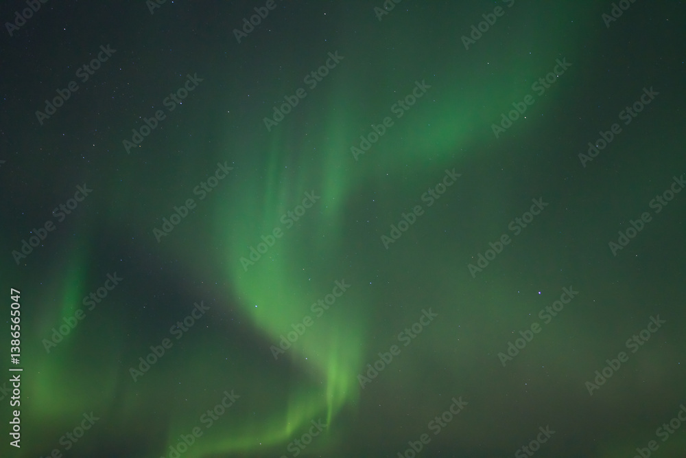 Polar Lights (Aurora borealis). Green northern lights and stars are visible in the dark night sky. Amazing nature of the Arctic. The photo is perfect for the background.