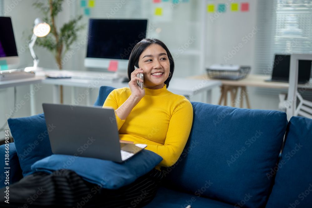 Naklejka premium A woman is sitting on a couch and talking on her cell phone