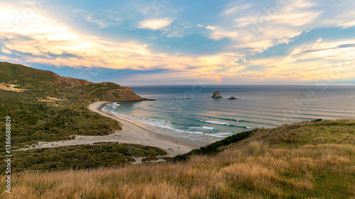 sunset over stunning Sandfly Bay with powerful waves. Amazing beach with striking rock formations in the ocean, Otago Peninsula, Dunedin, South Island, New Zealand