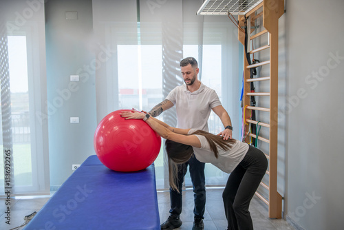 Physiotherapy exercises for a young woman’s back performed by a professional therapist