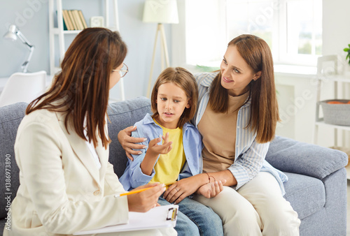 Obraz na płótnie Female professional doctor psychologist holding a consultation or conversation with a mother and son during a family psychotherapy session, focusing on good mental health, therapy needs. w salonie