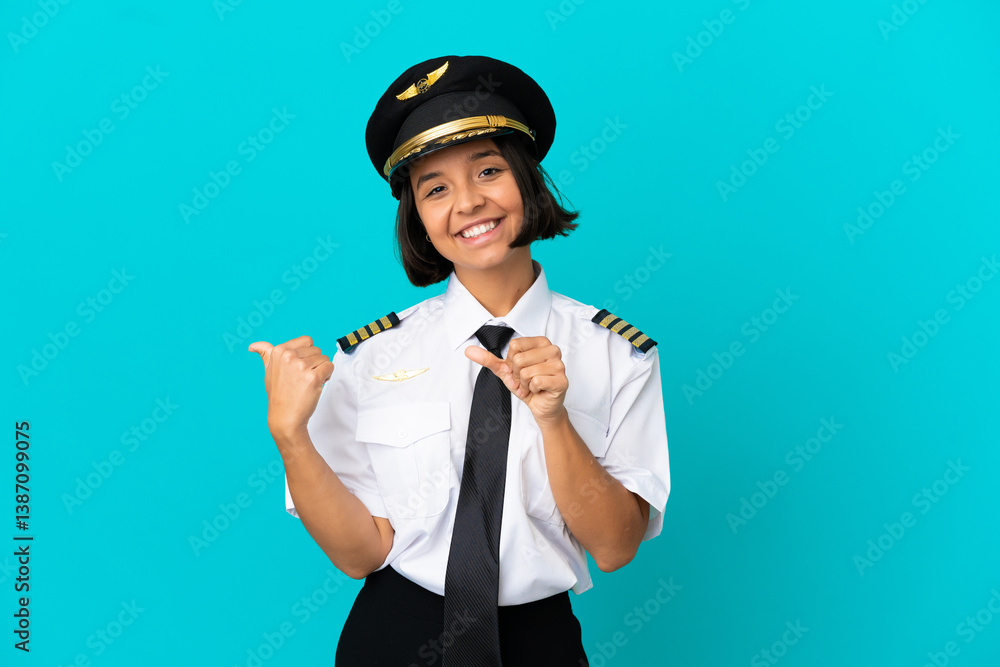 Young airplane pilot over isolated blue background pointing to the side to present a product Young airplane pilot over isolated blue background pointing to the side to present a product
