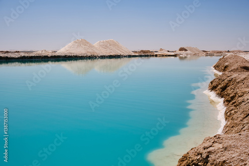 Salt lake with turquoise water and white salt hills on the shore. Siwa oasis, Western Desert, Egypt
