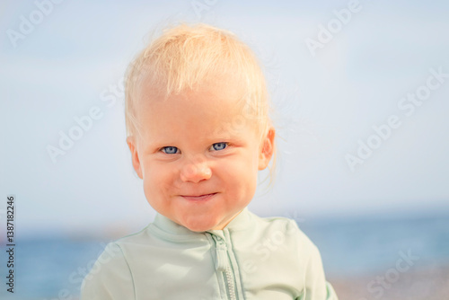 Obraz na płótnie A joyful child with a bright smile is playing at the beach, showcasing the essence of summer fun and pure innocence w salonie