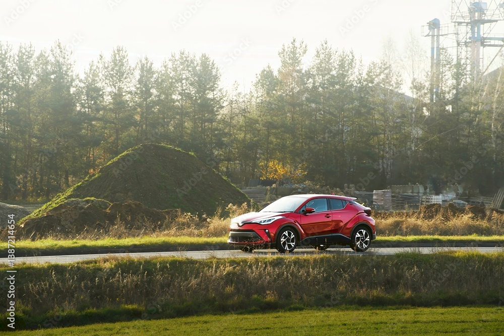 Vehicle cruising through forest at sunset
