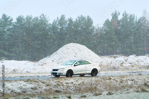 Obraz na płótnie A compact car driving on winter road w salonie