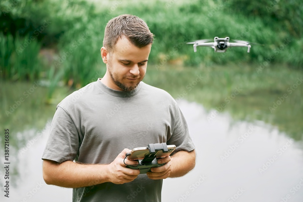 Man filming with UAV and camera in green meadow