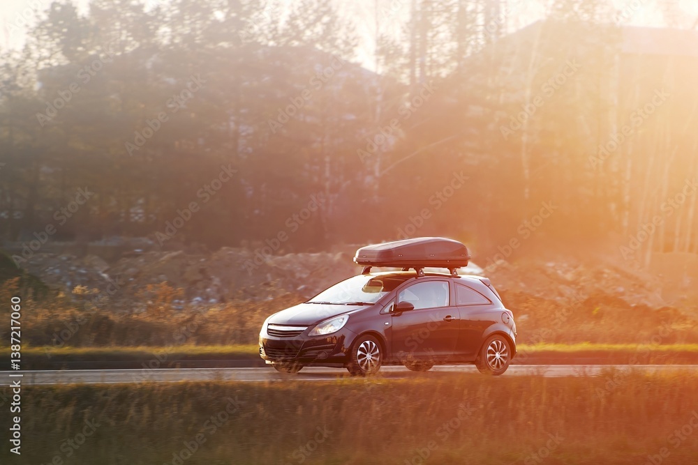Automobile with roof rack and cargo trunk on journey