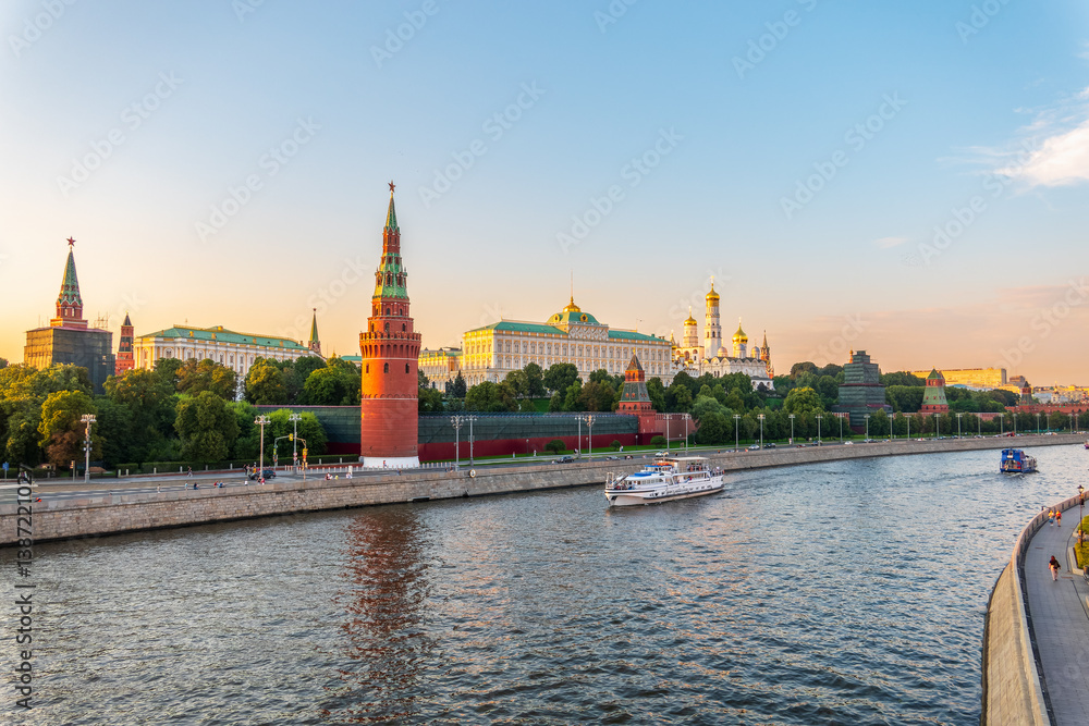 View of Kremlin with Vodovzvodnaya tower, Grand Kremlin Palace from repaired Bolshoy Kamenny Bridge in Moscow city on sunny summer day. Cruise ship sails on the Moscow river View of Kremlin with Vodovzvodnaya tower, Grand Kremlin Palace from repaired Bolshoy Kamenny Bridge in Moscow city on sunny summer day. Cruise ship sails on the Moscow river
