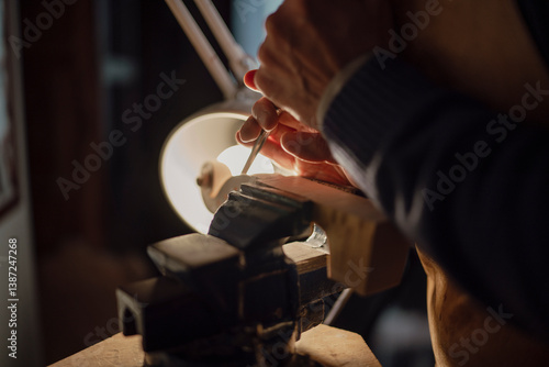Skilled woodworker carefully carving hardwood plank, clamped within workshop vise, using specialized gouge under soft lamplight, revealing intricate luthier craftsmanship