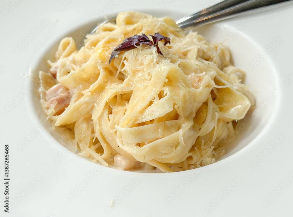 gourmet pasta dish, creamy fettuccine alfredo with grated cheese and a small garnish gourmet pasta dish, creamy fettuccine alfredo with grated cheese and a small garnish