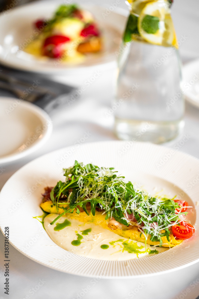 A beautifully plated dish featuring a vibrant salad with fresh greens, cherry tomatoes, and drizzled sauce. In the background, a bottle of water with lemon and mint adds a refreshing touch. A beautifully plated dish featuring a vibrant salad with fresh greens, cherry tomatoes, and drizzled sauce. In the background, a bottle of water with lemon and mint adds a refreshing touch.