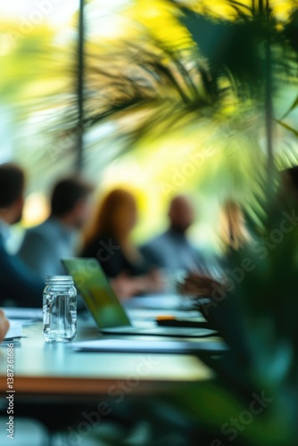Business professionals in a conference room focused on the person speaking, blurred background emphasizes attention and professionalism.