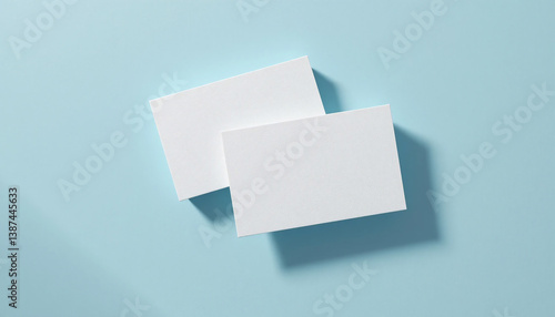 Two blank white cards floating on a light blue background, ideal for business card or credit card mockups