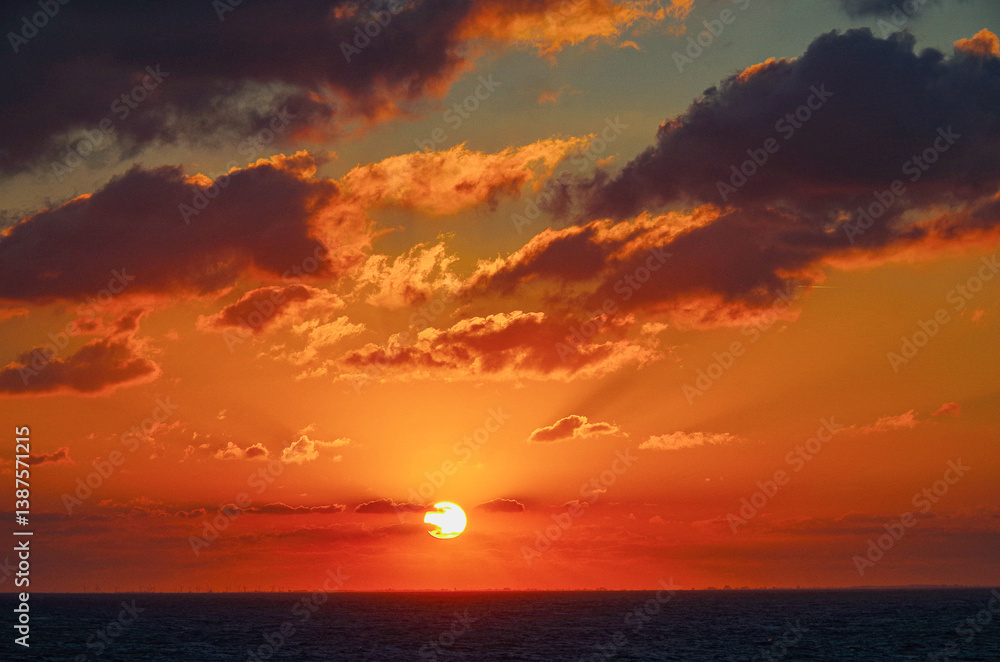 Beautiful breathtaking sunset blue hour twilight panorama at sea with dramatic sky seen from outdoor deck of classic cruiseship cruise ship liner sailing on ocean