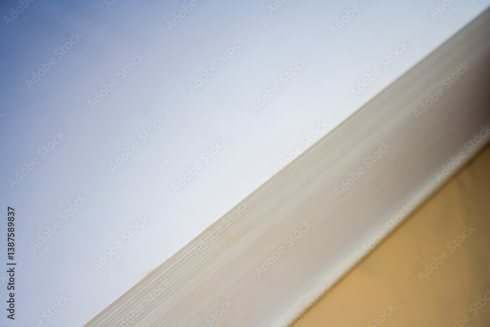 Obraz premium Abstract close-up of layered paper surfaces with soft lighting, showcasing texture and subtle color transitions for minimalistic backgrounds or design projects.
