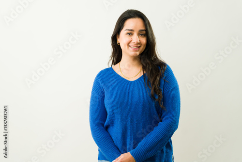 Photos Confident latina model wearing blue sweater, radiating warmth with genuine smile