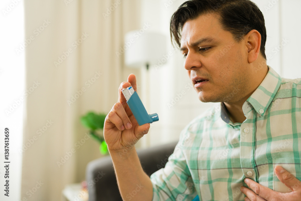 Closeup of a man managing asthma, using inhaler while resting on living room sofa