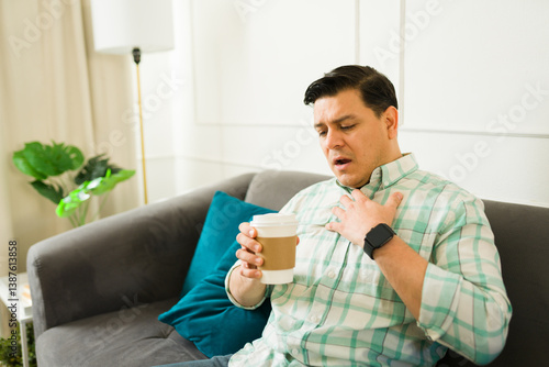 Fotografie Latin man suffering chest pain after drinking a coffee, experiencing a tachycard