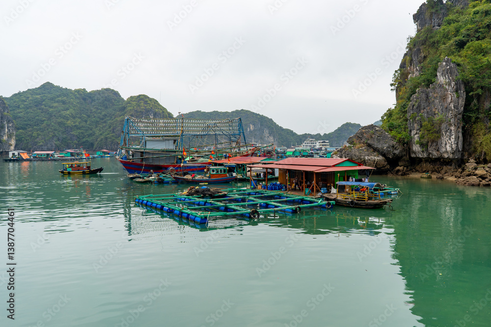 Fototapeta premium Picturesque view captures a fishing village in Ha Long Bay, Vietnam with boats.