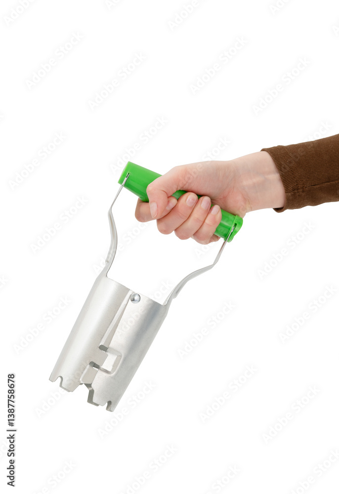 Hand holding a bulb planter tool with a green handle, isolated on white background. Hand holding a bulb planter tool with a green handle, isolated on white background.